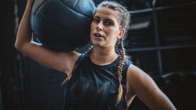 Athlete woman in gym practicing cross training with medicine ball