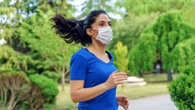 Woman running outdoors with a mask.