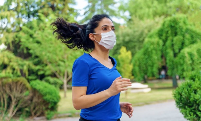 Woman running outdoors with a mask.