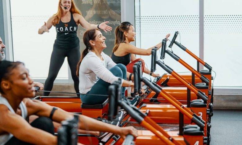 people on rowers doing the Orangetheory DriTri in a studio