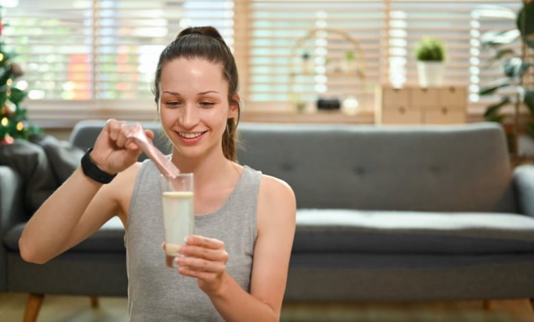 Woman dissolving collagen powder in a glass of water.