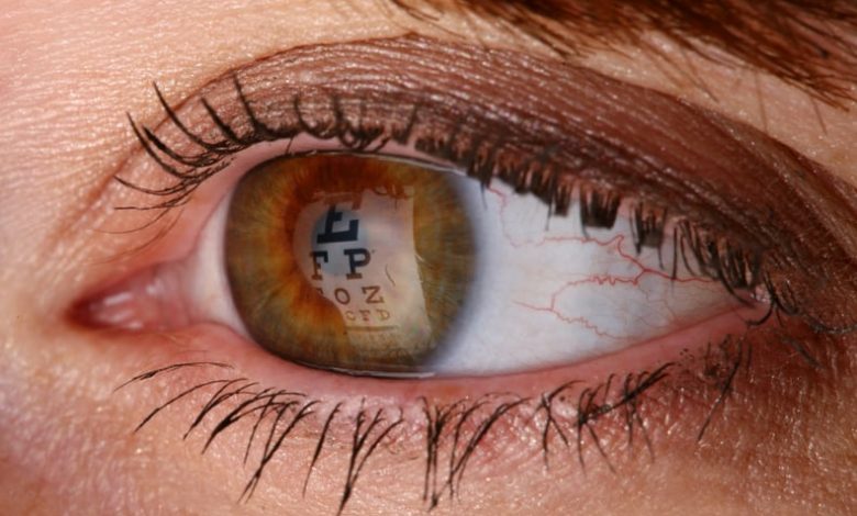 Macro shot of an Eye chart reflecting on the pupil. Woman taking an eye exam.